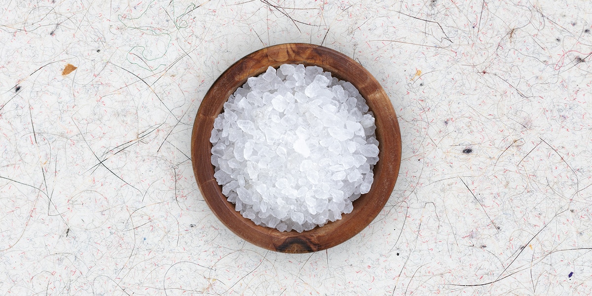 Disuelve 4 cucharadas de sal en un litro de agua caliente. Utiliza una esponja para tratar las manchas de sudor con esta solución y frota bien