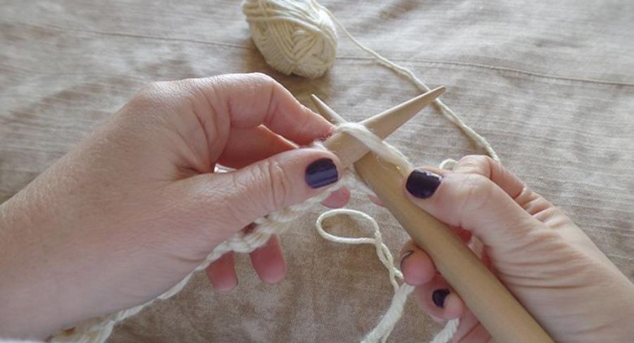 Tejiendo lana con agujas de madera